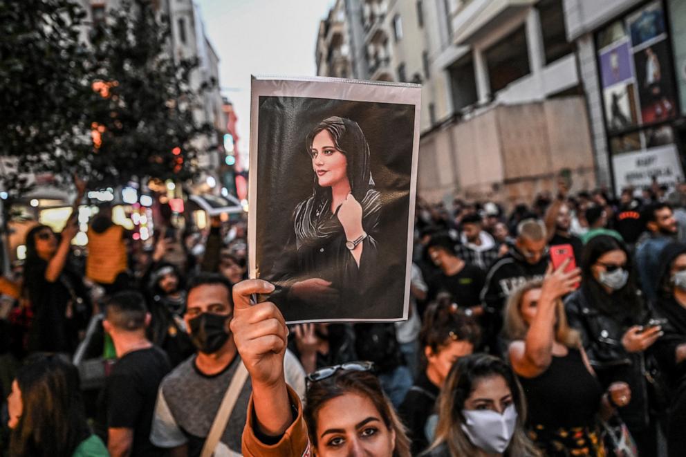 Protesters demonstrating with Mahsa Amini's portrait