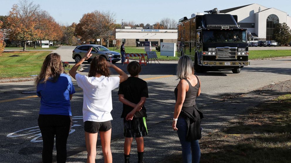 PHOTO: People look at a refrigerator truck near the Just-In-Time Recreation bowling alley, one of the locations of the deadly mass shootings, in Lewiston, Maine, Oct. 28, 2023.