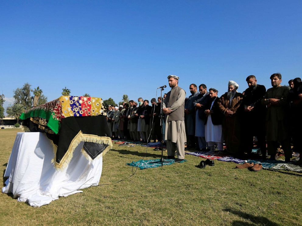 PHOTO: Afghan men pray near the coffin of journalist Malalai Maiwand, who was shot and killed by unknown gunmen in Jalalabad, Afghanistan, Dec. 10, 2020.