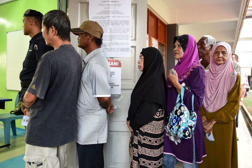 PHOTO: People queue outside a polling station during the 14th Malaysian general elections in Pekan on May 9, 2018.