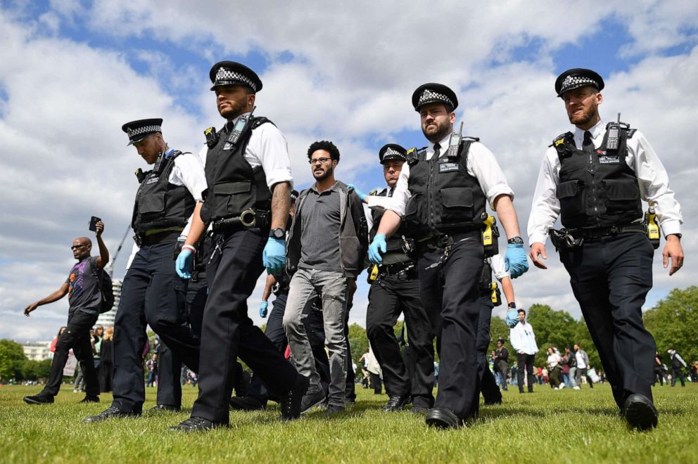 PHOTO: A man is led away by police officers at an anti-lockdown demonstration in Hyde Park in London, United Kingdom, on May 16, 2020, following an easing of restrictions in England amid the coronavirus pandemic.