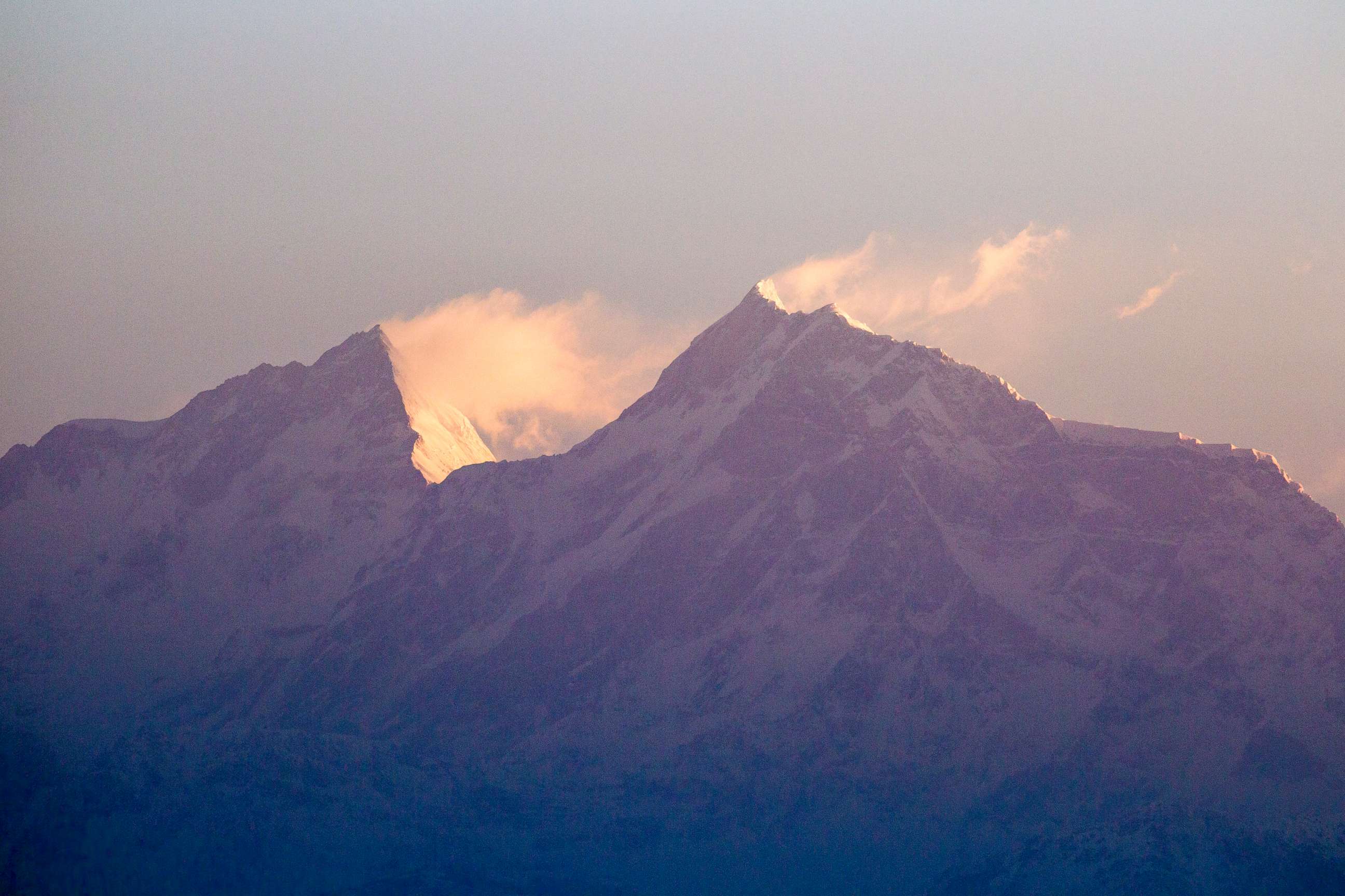 PHOTO: Sunrise on the peaks of Manaslu, left.