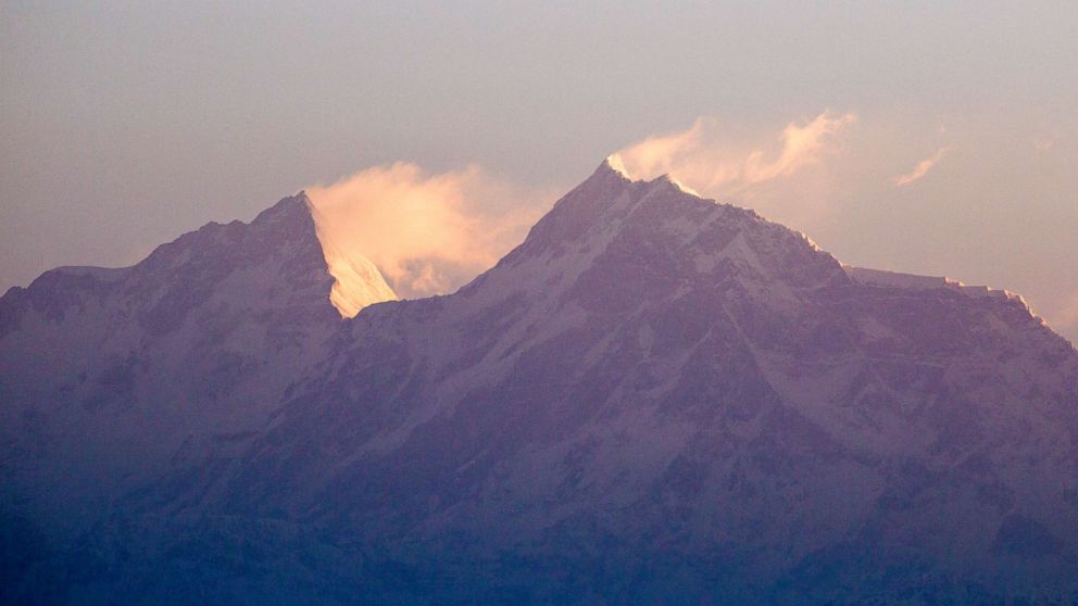 PHOTO: Sunrise on the peaks of Manaslu, left.