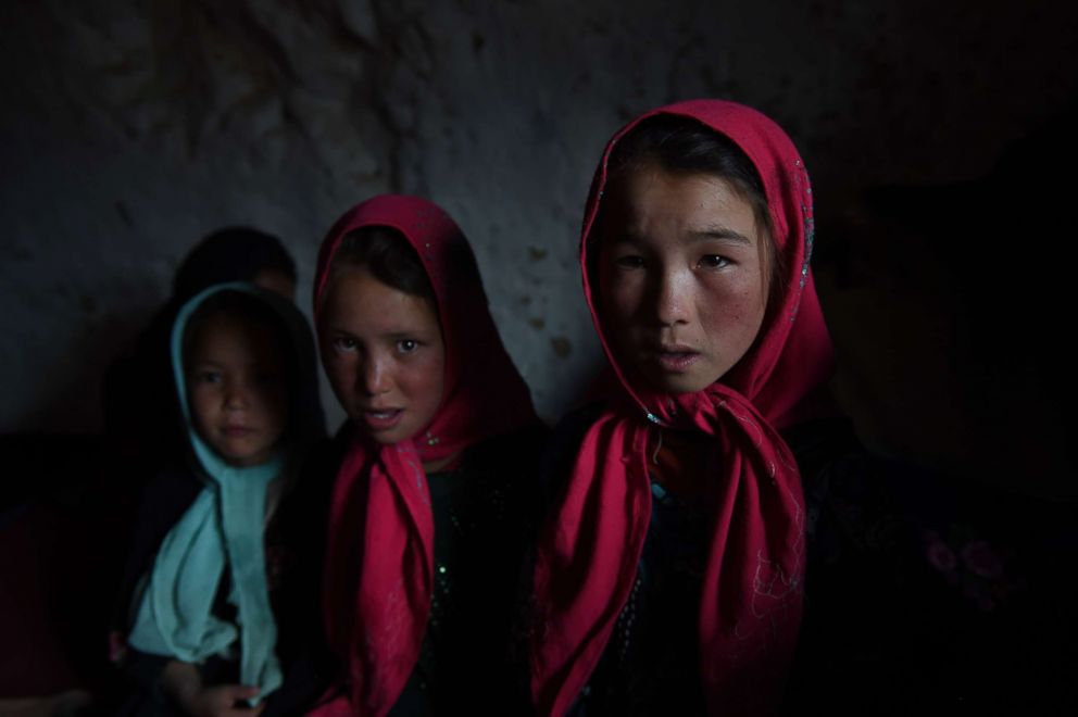 PHOTO: Hazara Afghan children sit inside their cave in the old city of Bamiyan, June 19, 2015.
