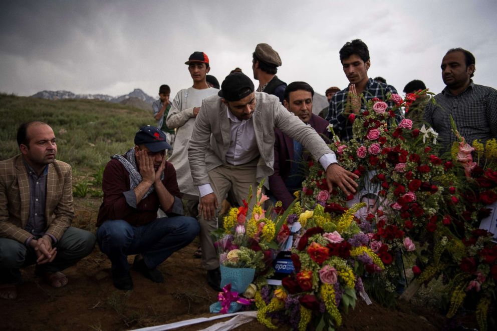 PHOTO: Friends and relatives of Agence France Presse (AFP) Afghanistan Chief Photographer Shah Marai Faizi gather at his burial in Gul Dara, Kabul, April 30, 2018, after his death in the second of two bombings that occurred in the Afghan capital. 
