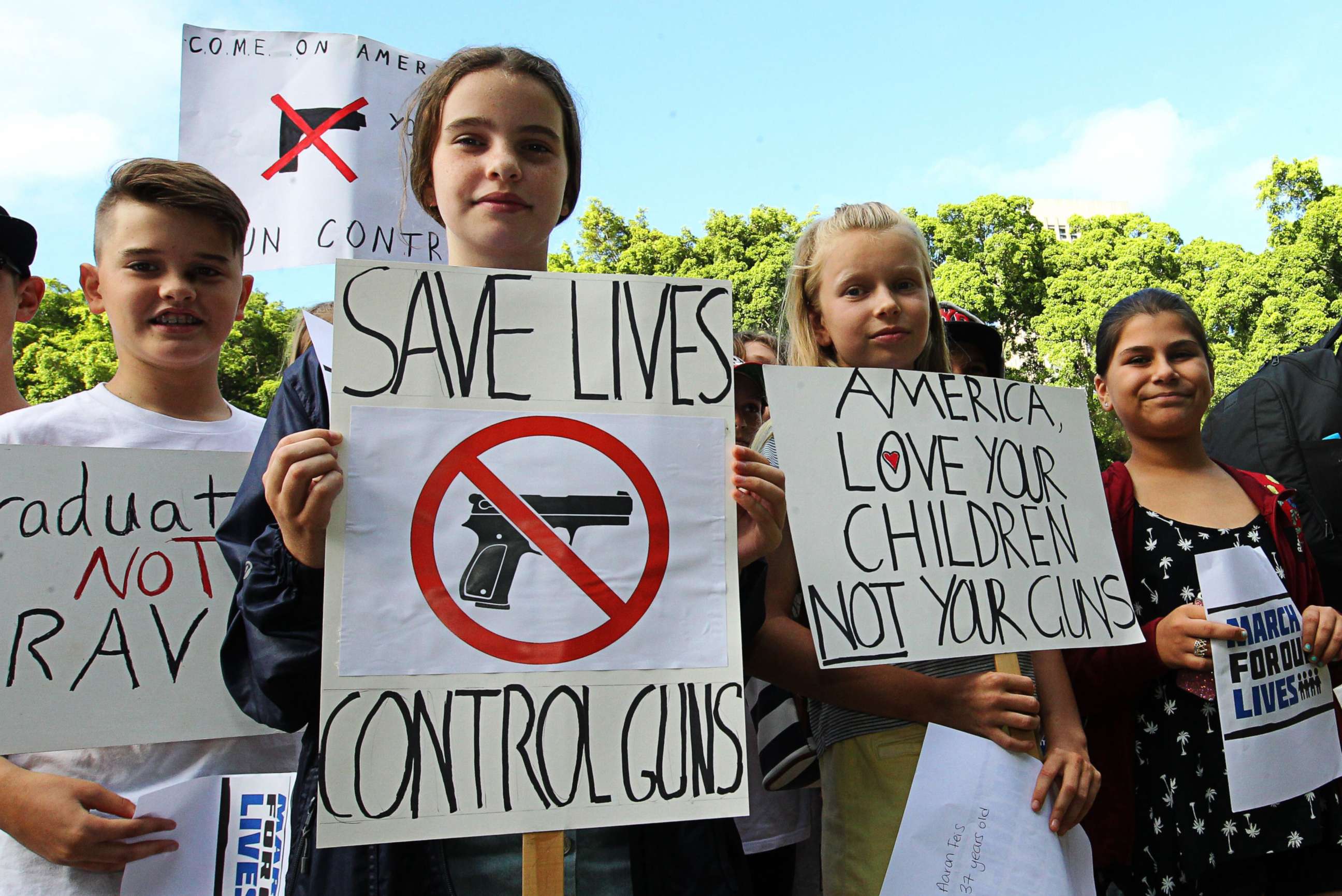 PHOTO: Young protesters hold placards at Hyde Park in Sydney, Australia, March 24, 2018, during the March for Our Lives protest.