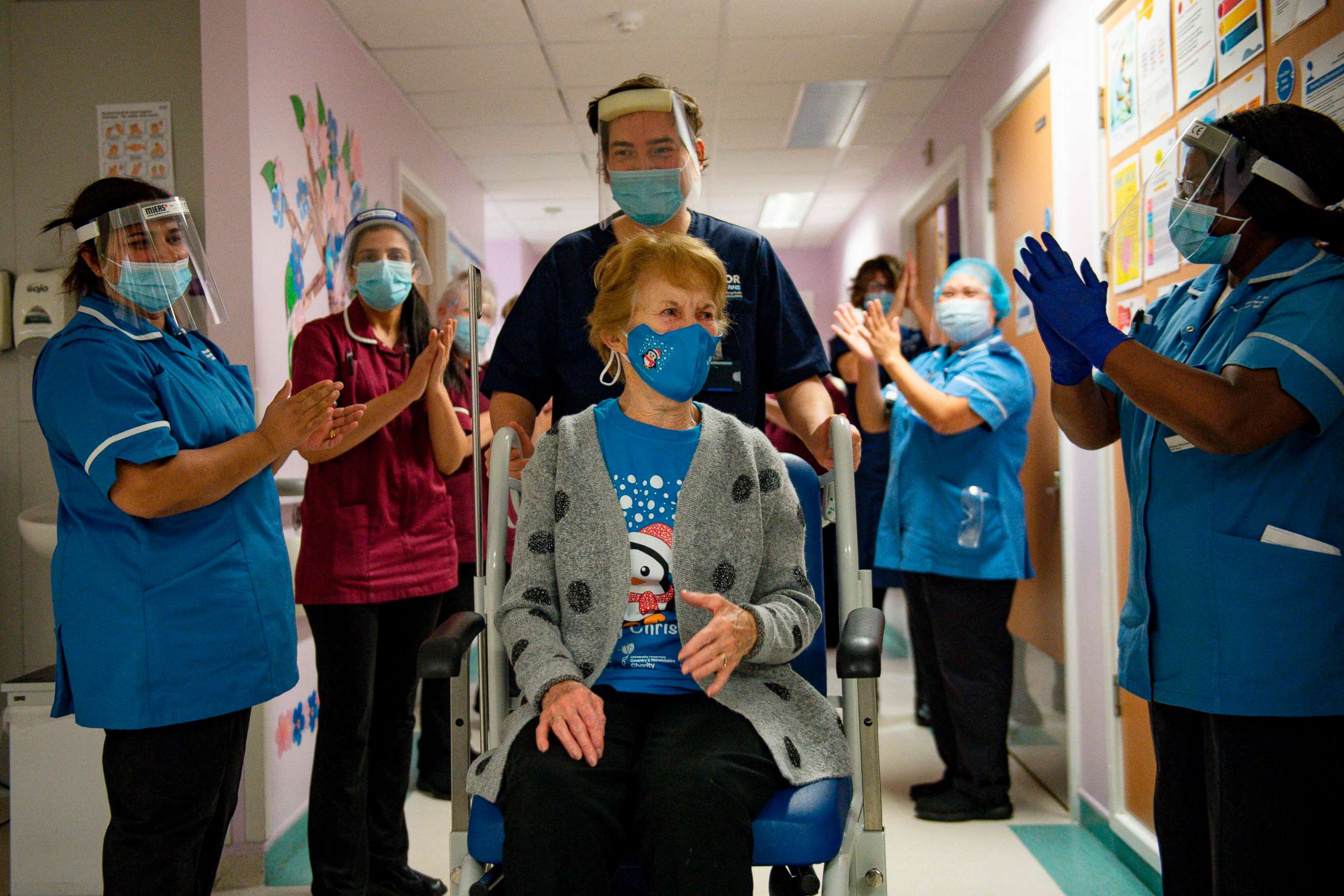 PHOTO: Margaret Keenan, 90, is applauded by staff as she is wheeled back to her ward after becoming the first person to receive the Pfizer/BioNtech COVID-19 vaccine outside a clinical trial at University Hospital Coventry in England on Dec. 8, 2020.