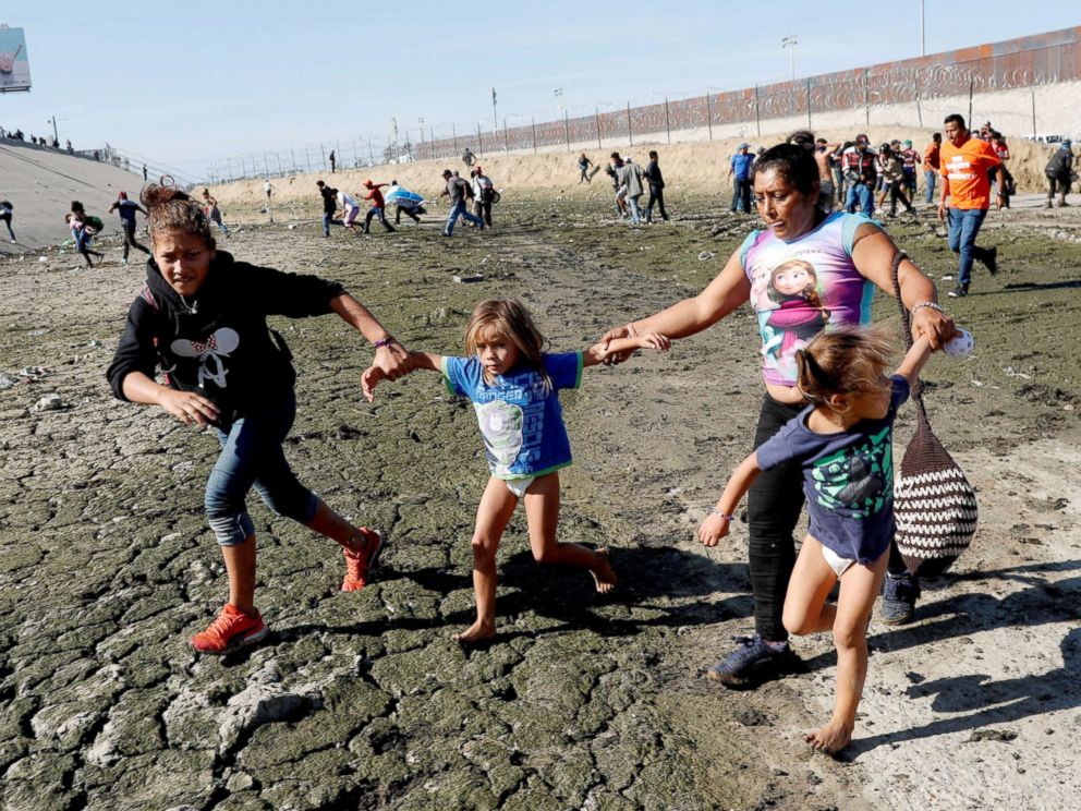 PHOTO: Maria Meza runs away from tear gas with her daughters Jamie Mejia Meza, aged 12 and her five-year-old twin daughters Saira Mejia Meza and Cheili Mejia Meza in front of the border wall between the U.S and Mexico, in Tijuana, Mexico Nov. 25, 2018.