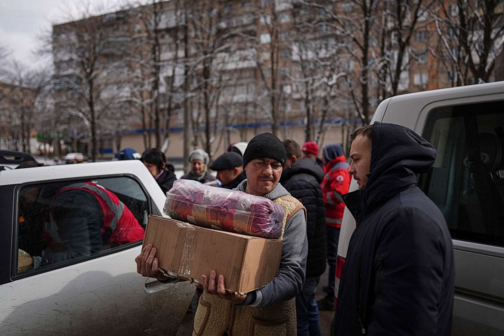 PHOTO: People receive humanitarian aid in Mariupol, Ukraine, March 8, 2022.