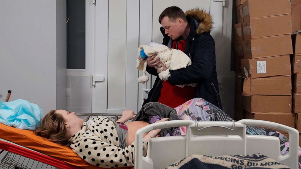 PHOTO: Mariana Vishegirskaya lies in a hospital bed after giving birth to her daughter Veronika, held by her husband Yuri, in Mariupol, Ukraine, March 11, 2022. 