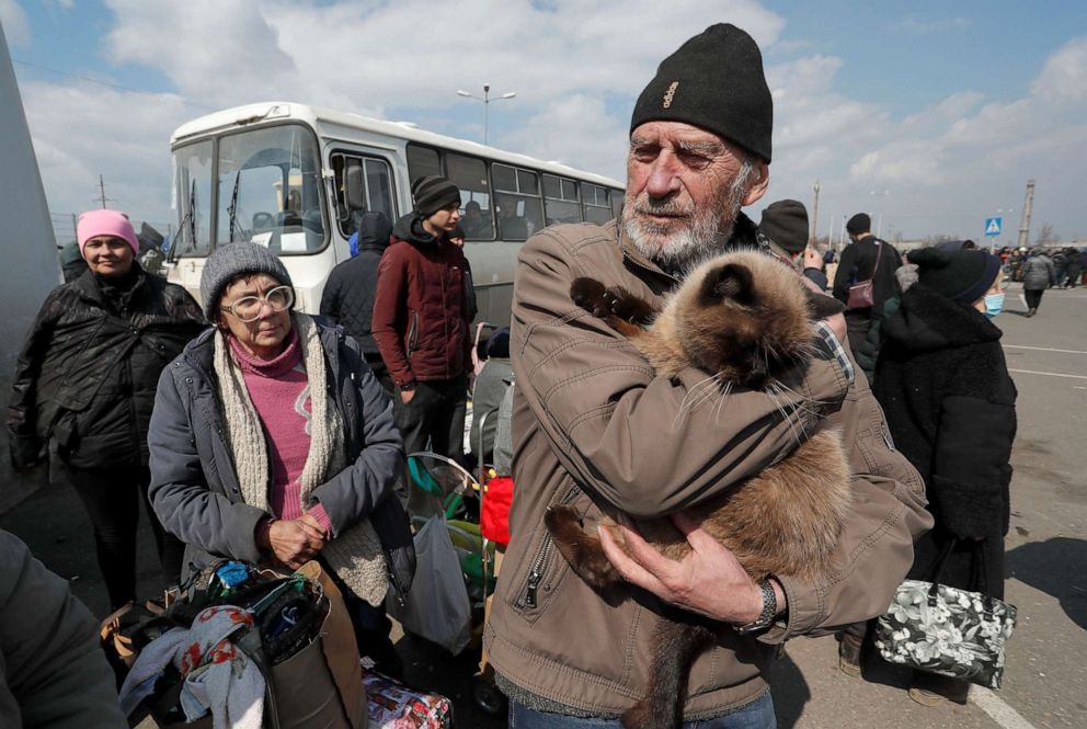 PHOTO: A man holds a cat as evacuees wait before boarding a bus to leave Mariupol, Ukraine, April 5, 2022.