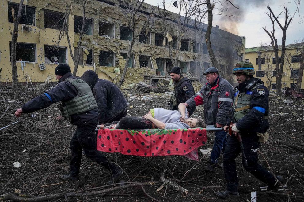 PHOTO: Ukrainian emergency employees and volunteers carry an injured pregnant woman from a maternity hospital destroyed by shelling in Mariupol, Ukraine, March 9, 2022. The woman and her child died at another hospital. 