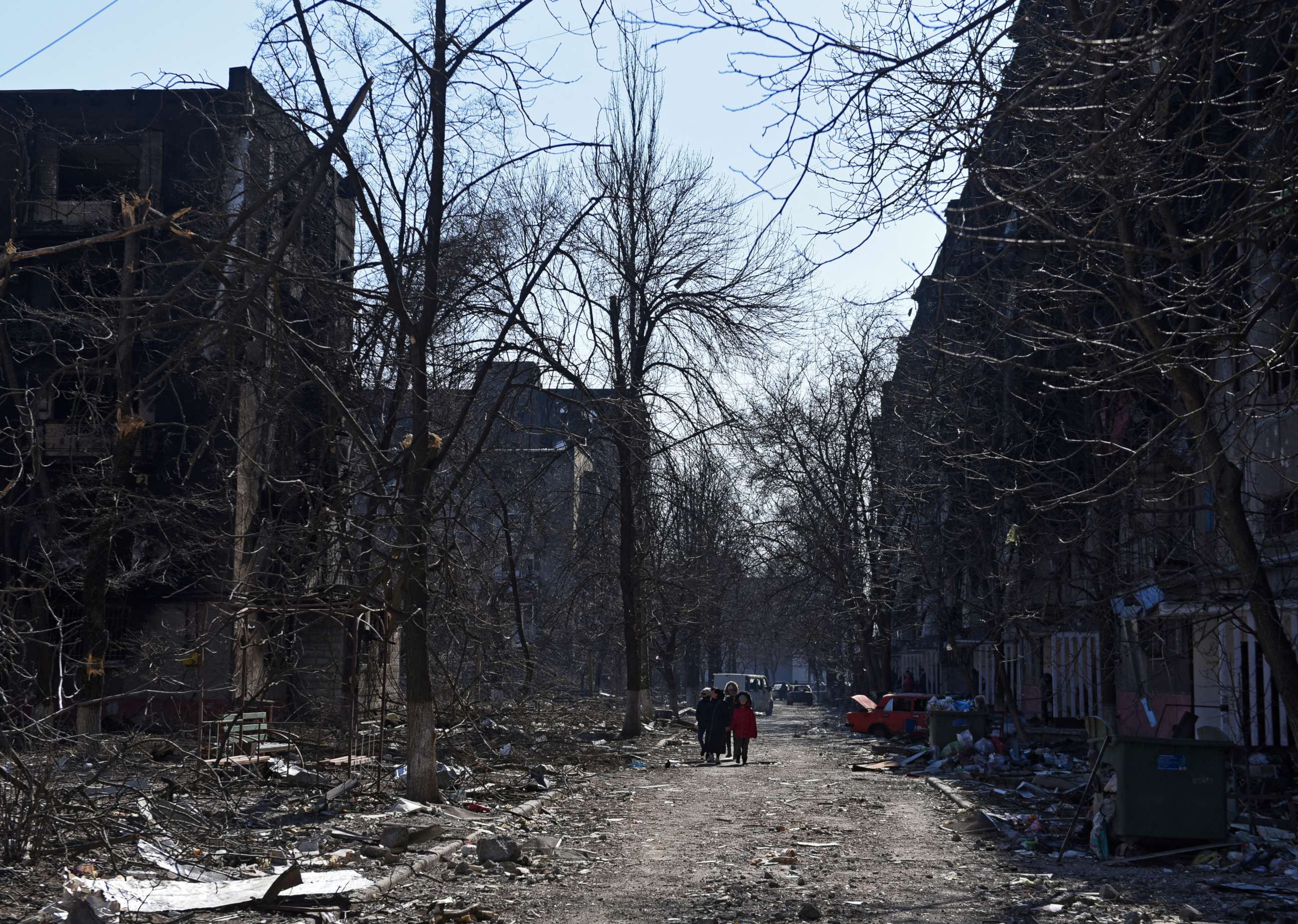 PHOTO: Local residents walk near residential buildings which were damaged during Ukraine-Russia conflict in the besieged southern port city of Mariupol, Ukraine, March 18, 2022.