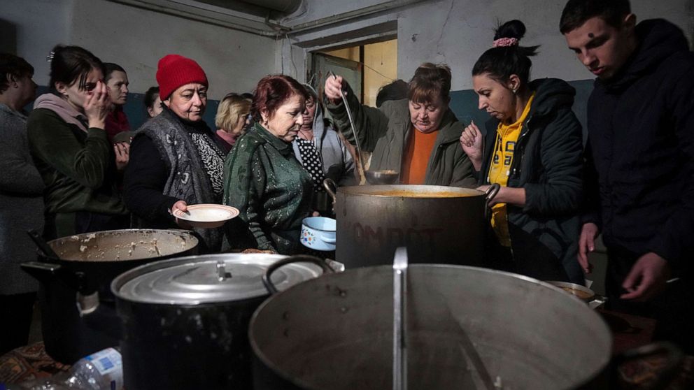 PHOTO: People queue to receive hot food in the improvised bomb shelter in Mariupol, Ukraine, March 7, 2022.