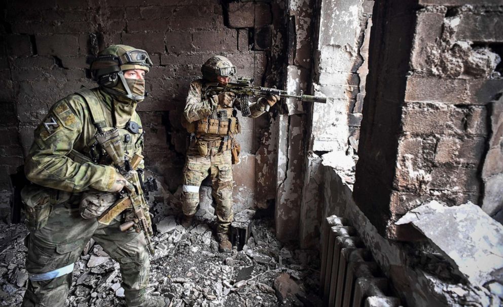 PHOTO: Russian soldiers patrol at the Mariupol drama theatre, hit on March 16 by an airstrike, on April 12, 2022, in Mariupol, Ukraine. This picture was taken during a trip organized by the Russian military.
