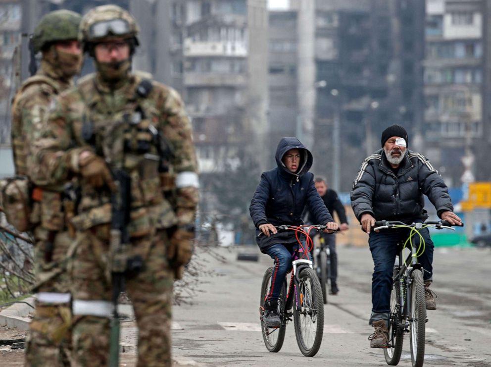 PHOTO: A picture taken during a visit to Mariupol organized by the Russian military shows local people arriving as Russian servicemen guard during distribution of humanitarian aid to local people in Mariupol, Ukraine, on April 12, 2022.