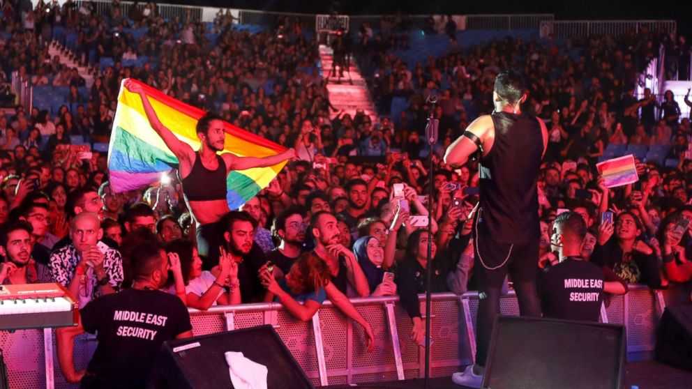 A fan of Lebanese alternative rock band Mashrou' Leila holds a rainbow flag during their concert at the Ehdeniyat International Festival in Ehden town, Lebanon, Aug. 12, 2017.