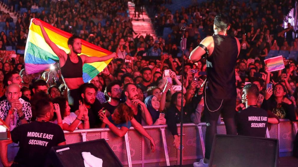 A fan of Lebanese alternative rock band Mashrou' Leila holds a rainbow flag during their concert at the Ehdeniyat International Festival in Ehden town, Lebanon, Aug. 12, 2017.