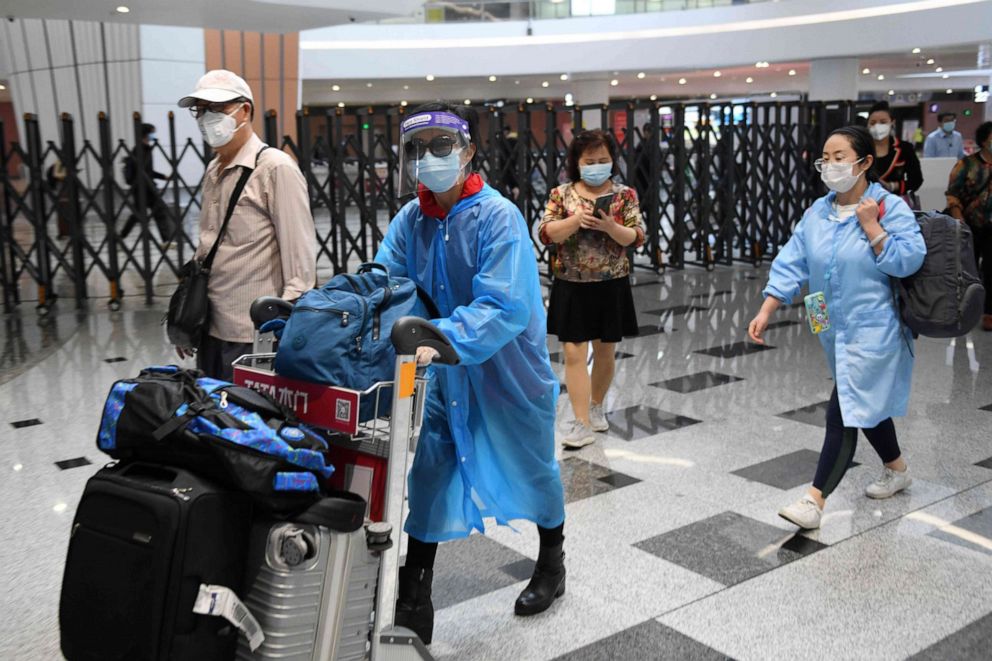 PHOTO: Travelers wear face masks amid concerns of the novel coronavirus as they arrive from a flight at Beijing Daxing International Airport on the eve of a five-day national holiday in China on April 30, 2020.
