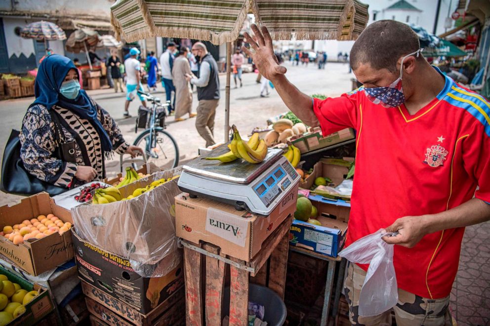 PHOTO: A vendor wearing a face mask weighs bananas at the central market during the Muslim holy month of Ramadan in Morocco's capital, Rabat, on May 6, 2020.