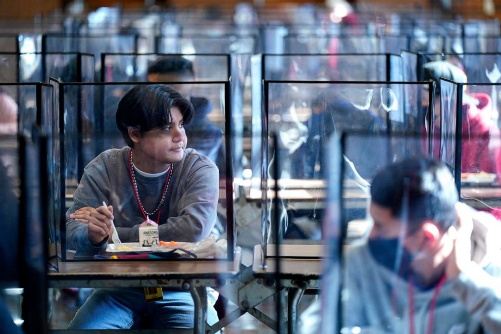 PHOTO: Students sit separated by plastic dividers during lunch at Wyandotte County High School in Kansas City, Kan., March 21, 2021.