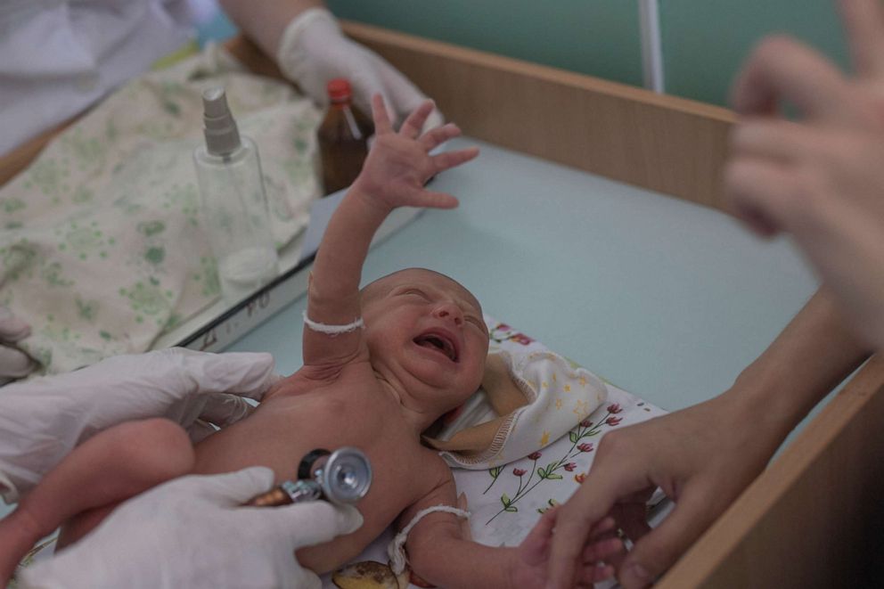 PHOTO: Marina Tupata, 26, watches as her six-day-old baby Sofia is examined inside Pokrovsk maternity hospital, Donetsk region, eastern Ukraine, June 29, 2022.