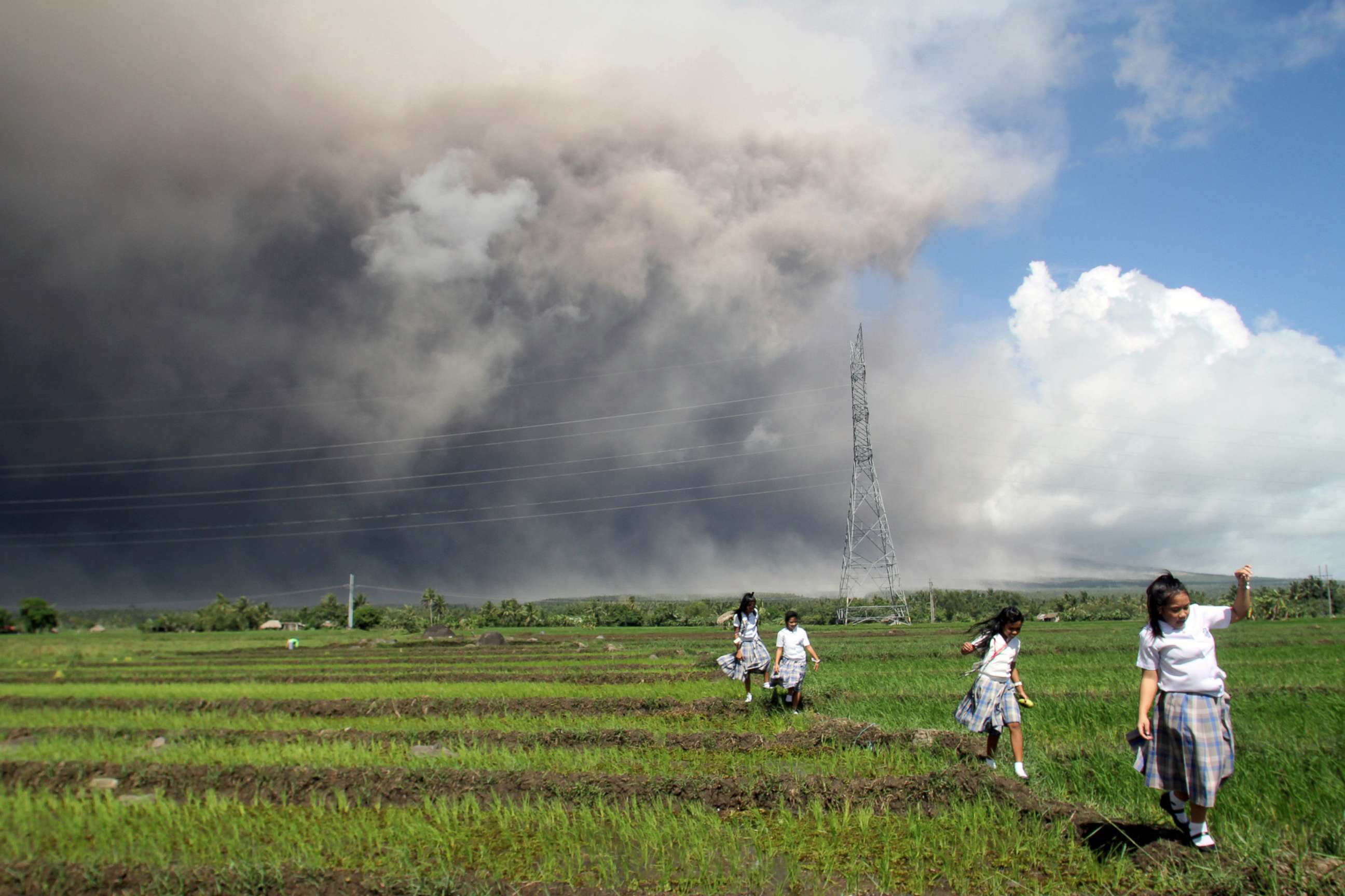 PHOTO: Students passes through a rice paddy as they run away from cascading volcanic materials from the slopes of Mayon Volcano in Guinobatan, Albay province, south of Metro Manila, Philippines, Jan. 22, 2018.