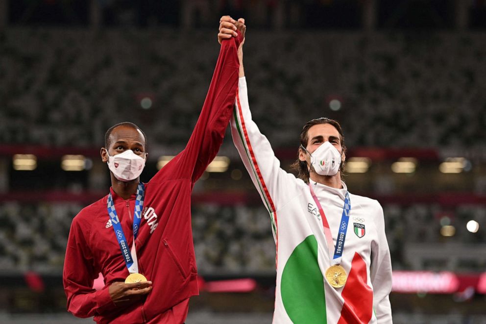 PHOTO: Joint gold medalists Qatar's Mutaz Essa Barshim, left and Italy's Gianmarco Tamberi pose on the podiumn of the men's high jump final during the Tokyo 2020 Olympic Games at the Olympic Stadium in Tokyo on Aug. 2, 2021.