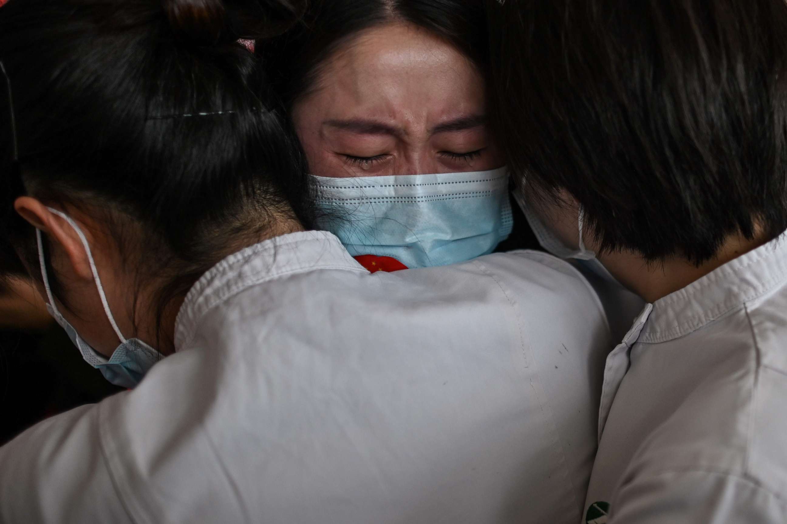 PHOTO: A medical worker from China's Jilin province (center) hugs nurses after working together during the coronavirus outbreak before leaving as Wuhan Tianhe International Airport is reopened in Wuhan in China's Hubei province on April 8, 2020.