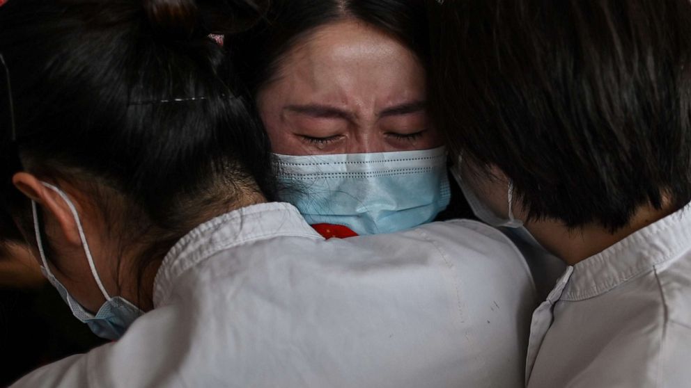 PHOTO: A medical worker from China's Jilin province (center) hugs nurses after working together during the coronavirus outbreak before leaving as Wuhan Tianhe International Airport is reopened in Wuhan in China's Hubei province on April 8, 2020.