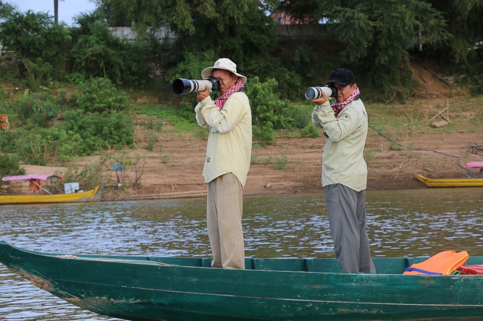 PHOTO: Researchers conduct a population survey from a boat in the Mekong river of Irrawaddy river dolphins in Cambodia.