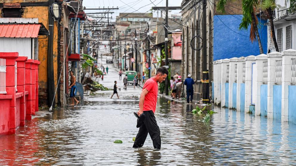 PHOTO: A man walks through a flooded street in a neighborhood affected by Hurricane Melissa in Santiago de Cuba, October 29, 2025. 