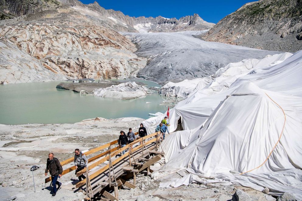 PHOTO: People visit the Rhone Glacier covered in blankets to protect it from the sun, above Gletsch near the Furkapass in Switzerland, July 13, 2022.