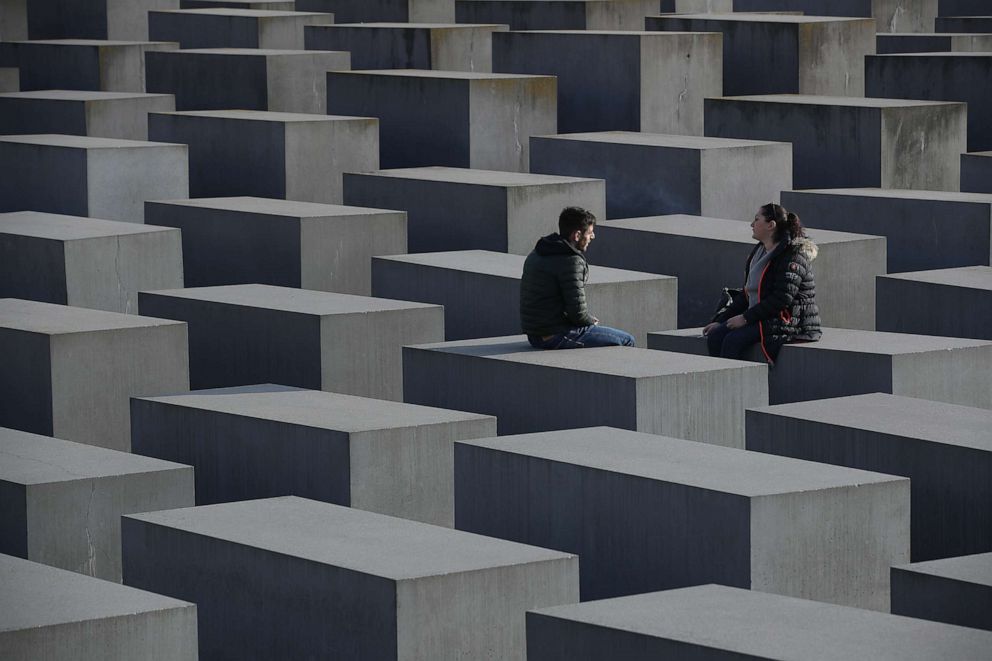 PHOTO: Two visitors sit on the Monument to the Murdered Jews of Europe, also called the Holocaust Memorial, Nov. 7, 2018, in Berlin.