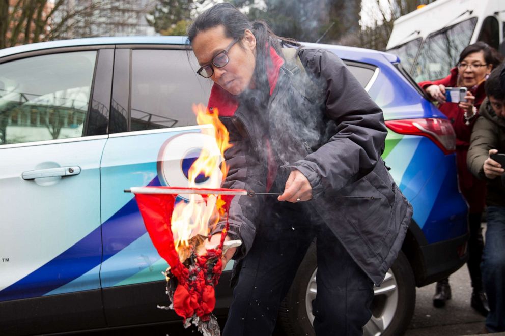 PHOTO: A man burns a Chinese flag to protest human rights abuses outside a British Columbia Supreme Court where Huawei Chief Financial Officer Meng Wanzhou appeared for an extradition hearing in Vancouver, March 6, 2019.