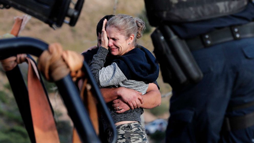 PHOTO: Framed by heavily armed Mexican authorities, relatives of the LeBaron family mourn at the site where nine U.S. citizens, were killed, at the Sonora-Chihuahua border, Mexico, Nov 6, 2019. 