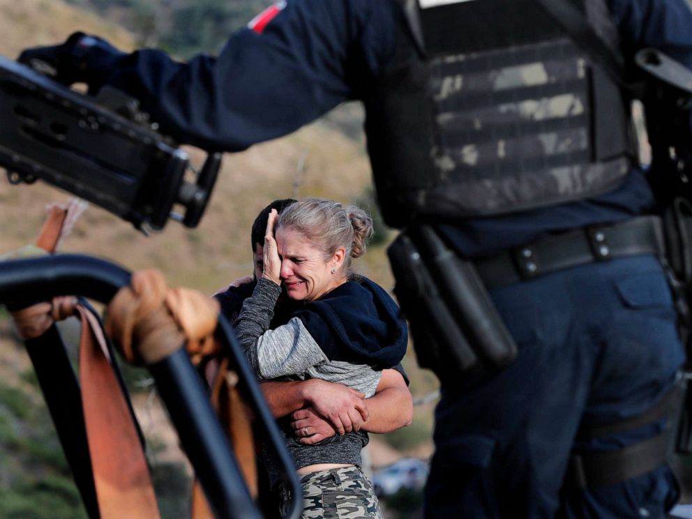 PHOTO: Framed by heavily armed Mexican authorities, relatives of the LeBaron family mourn at the site where nine U.S. citizens, were killed, at the Sonora-Chihuahua border, Mexico, Nov 6, 2019.