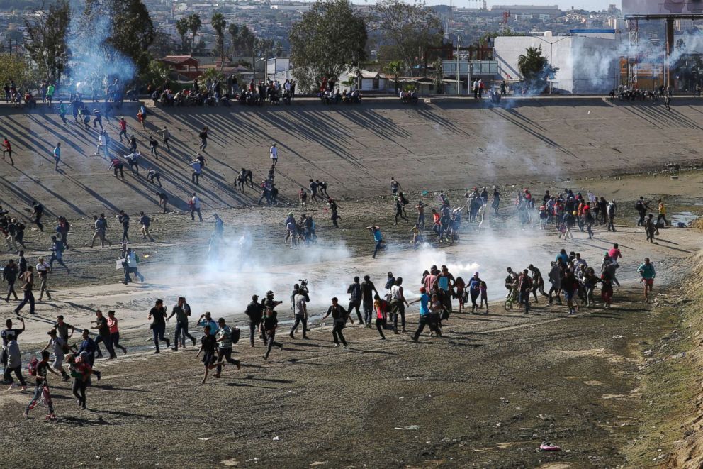 PHOTO: Migrants run from tear gas, thrown by the U.S border patrol, near the border fence between Mexico and the U.S. in Tijuana, Mexico, Nov. 25, 2018.