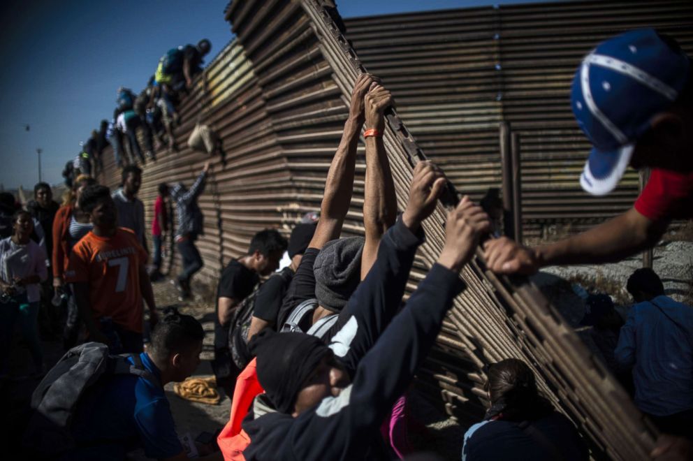 PHOTO: A group of Central American migrants climb the border fence between Mexico and the United States, near El Chaparral border crossing, in Tijuana, Mexico, Nov. 25, 2018. 