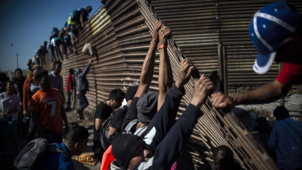 PHOTO: A group of Central American migrants climb the border fence between Mexico and the United States, near El Chaparral border crossing, in Tijuana, Mexico, Nov. 25, 2018. 
