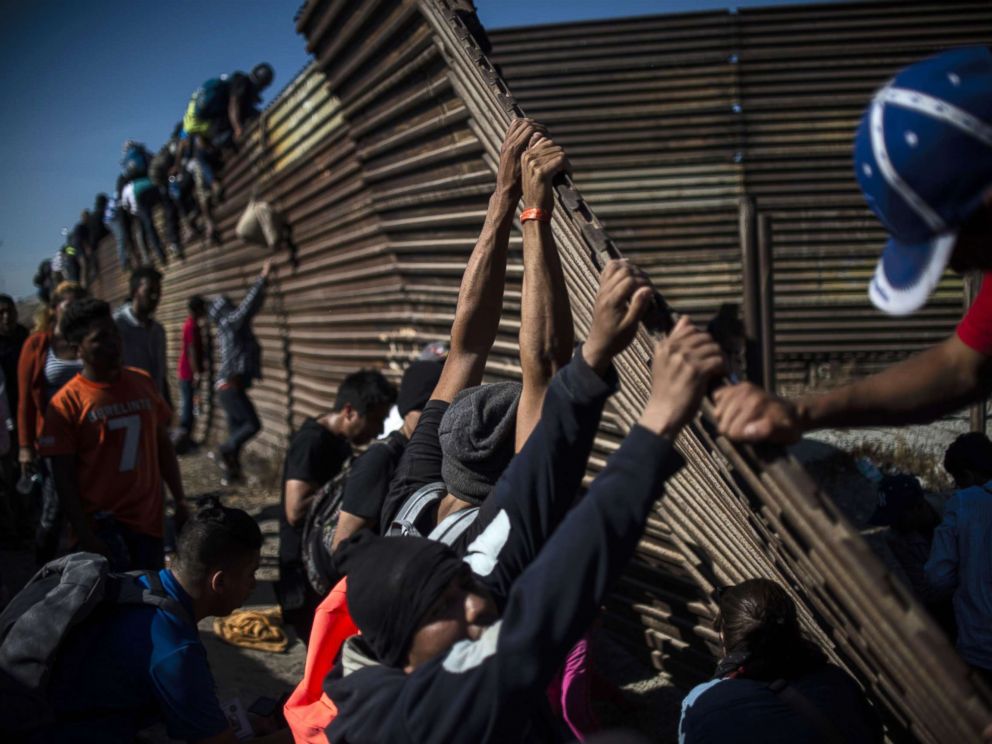PHOTO: A group of Central American migrants climb the border fence between Mexico and the United States, near El Chaparral border crossing, in Tijuana, Mexico, Nov. 25, 2018.