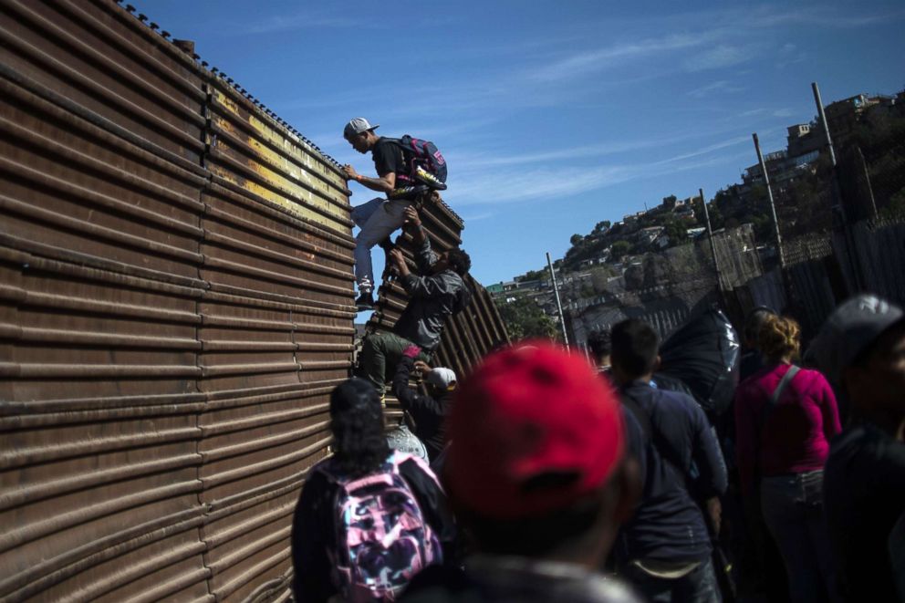 PHOTO: A group of Central American migrants climb the border fence between Mexico and the U.S. near El Chaparral border crossing, in Tijuana, Mexico, Nov. 25, 2018.