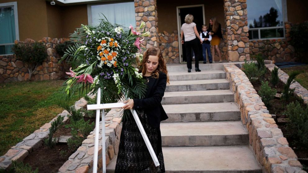 PHOTO: A relative carries a wreath before the funeral of Dawna Ray Langford and her two children, members of the Mexican-American Mormon community killed by unknown assailants, in La Mora, Sonora state, Mexico, Nov. 7, 2019.
