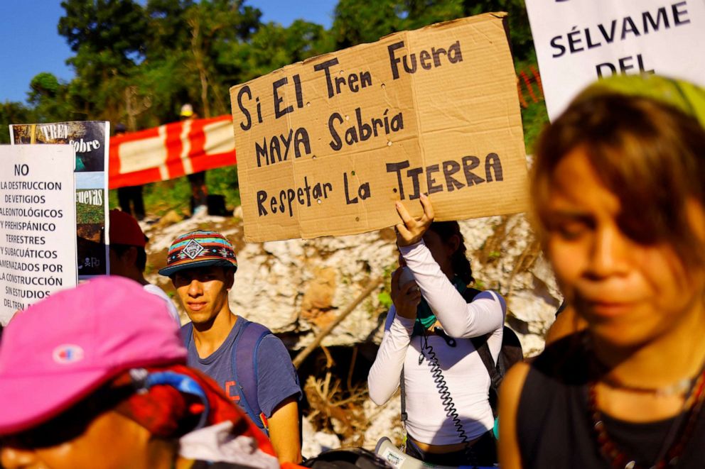 PHOTO: A protestor holds a sign as activists and locals protest the environmental impact of the new Mayan Train route, outside the Yorogana cave in Playa del Carmen, Quintana Roo, Mexico, November 5, 2022.
