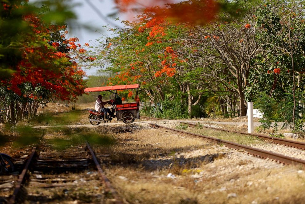 PHOTO: A man on a motorcycle crosses the old train tracks where section 3 of the new Mayan Train route was planned to be built before protests moved construction to the outskirts of the city, in Chochola, Yucatan, Mexico, May 16, 2022.