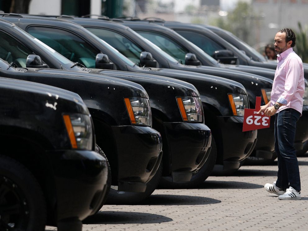 PHOTO: A man holding his auction paddle looks at vehicles on display to be auctioned at the Los Pinos Cultural Center, once the presidential residence, in Mexico City, Sunday, May 26, 2019.