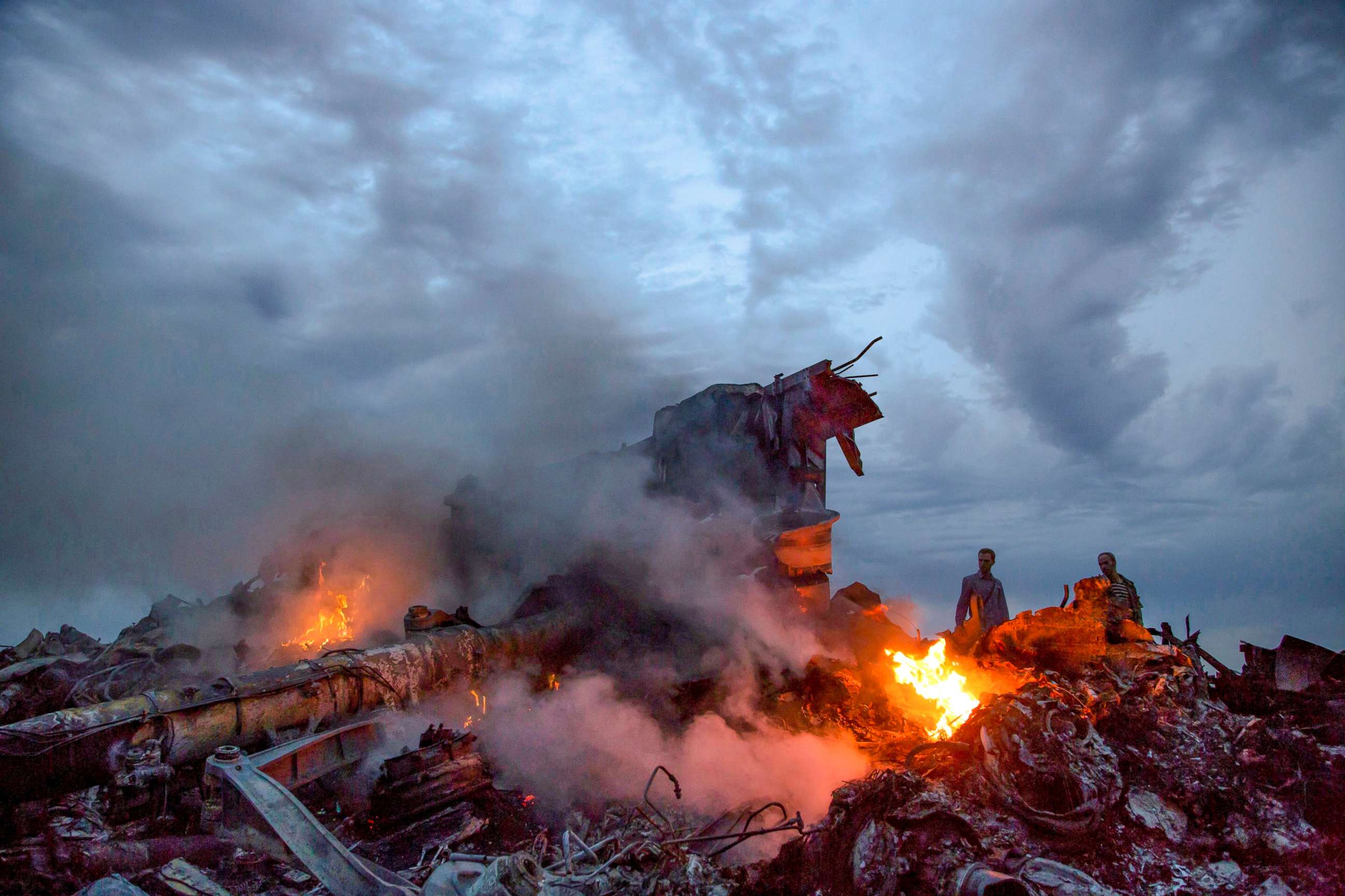 PHOTO: People walk through the debris at the crash site of Malaysia Airlines Flight 17 near the village of Grabove, Ukraine, July 17, 2014.