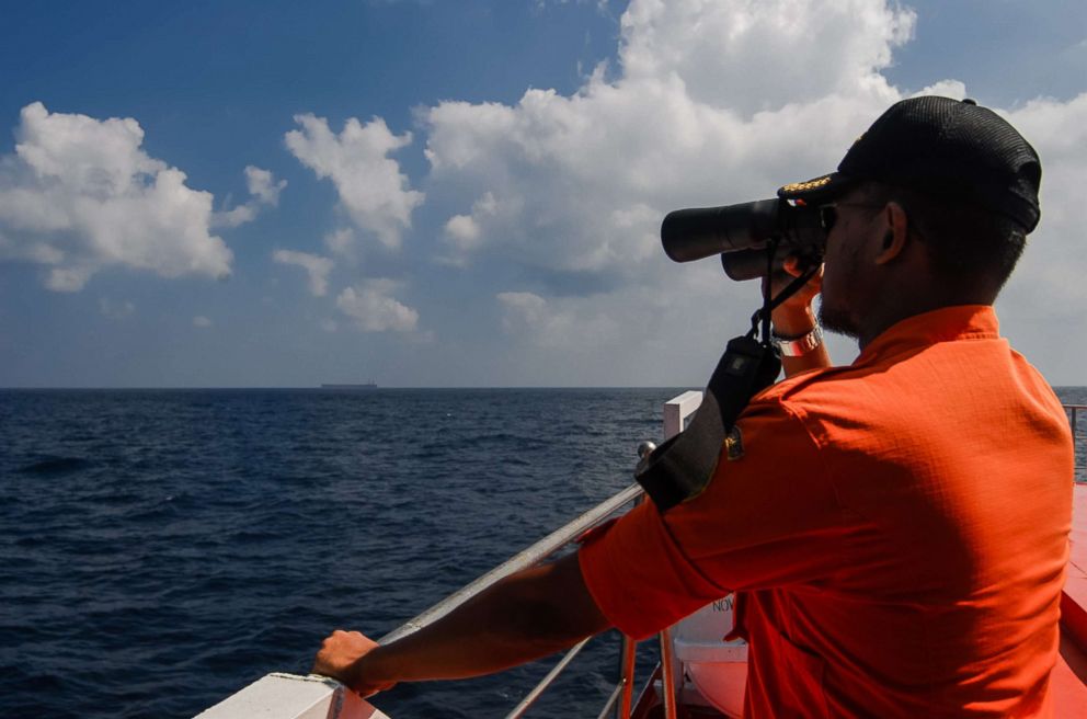 PHOTO: An Indonesian National Search and Rescue Agency personnel scans the seas aboard in the Malacca Strait off Aceh province on March 12, 2014 during the continued search for the missing Malaysia Airlines flight MH370.