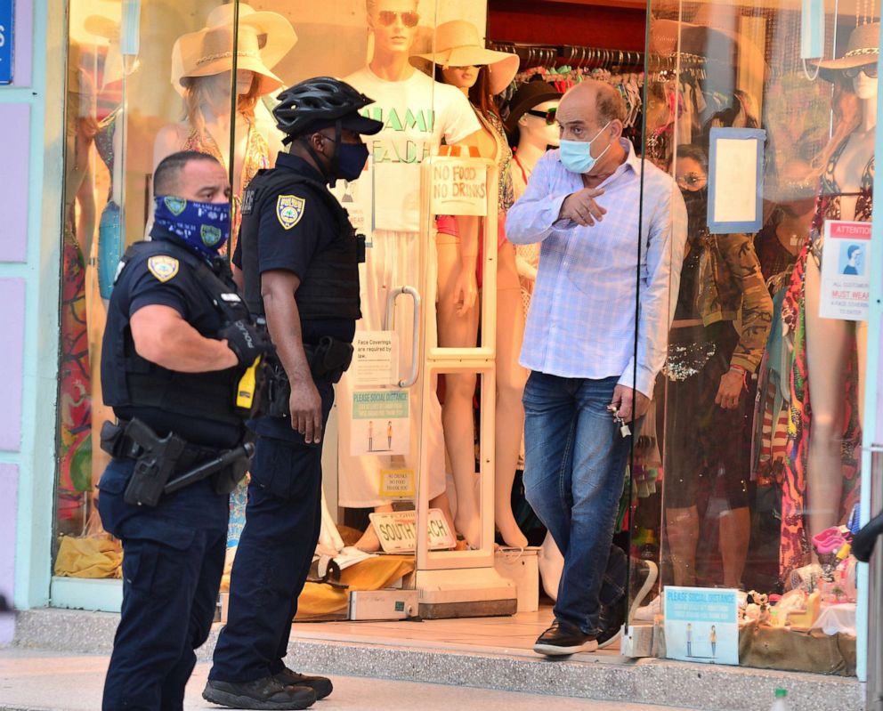 PHOTO: Miami Beach Police officer talks to a shop owner during patrol on Ocean Drive on in Miami Beach, Fla., July 15, 2020.