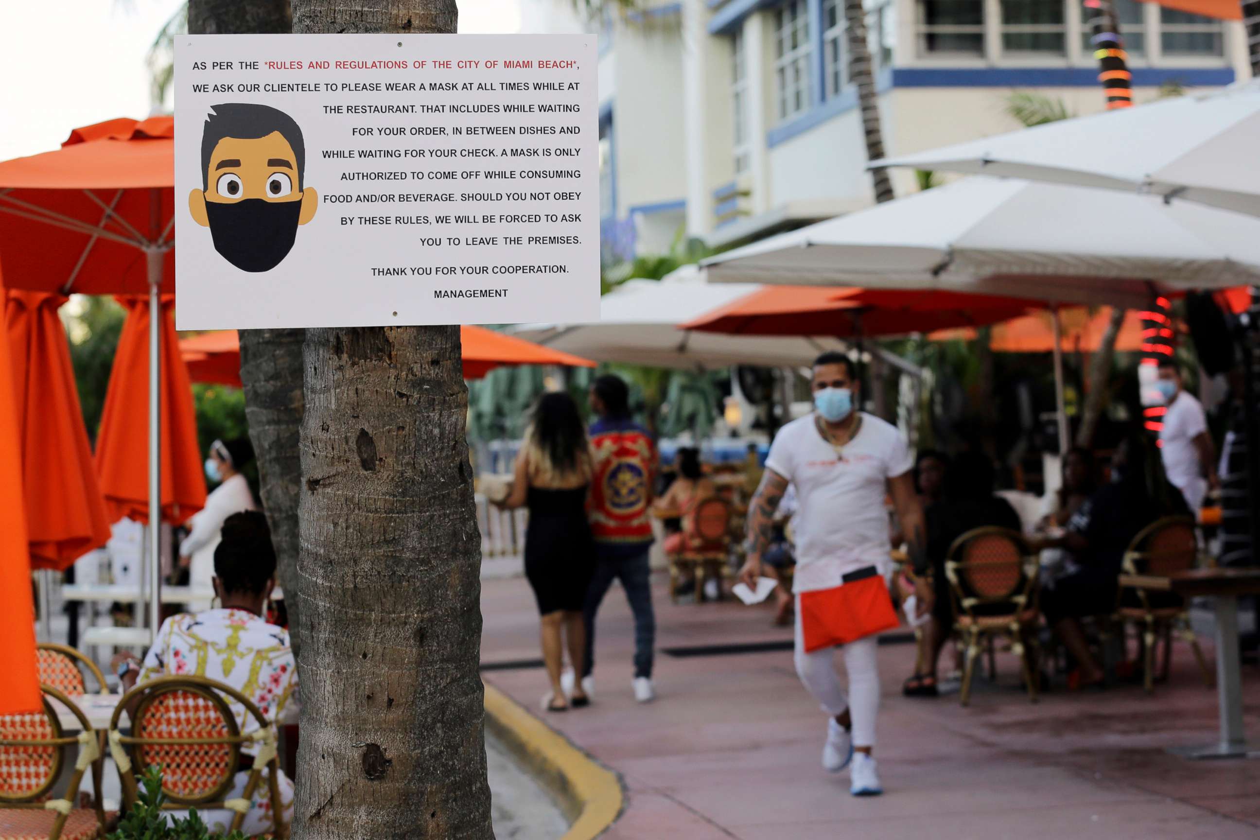 PHOTO: A sign informs customers at the Edison Hotel restaurant about wearing a protective face mask during the coronavirus pandemic, July 24, 2020, along Ocean Drive in Miami Beach, Fla.